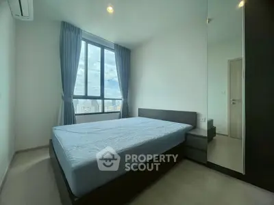 Modern bedroom with large window and city view, featuring sleek furniture and minimalist design.