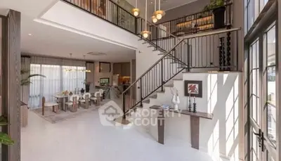 Spacious modern living room with high ceilings and elegant staircase in luxury home.