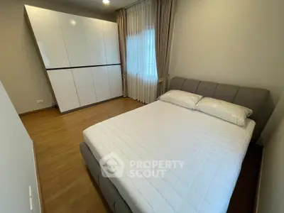 Modern bedroom with sleek wardrobe and cozy bed in a stylish apartment.