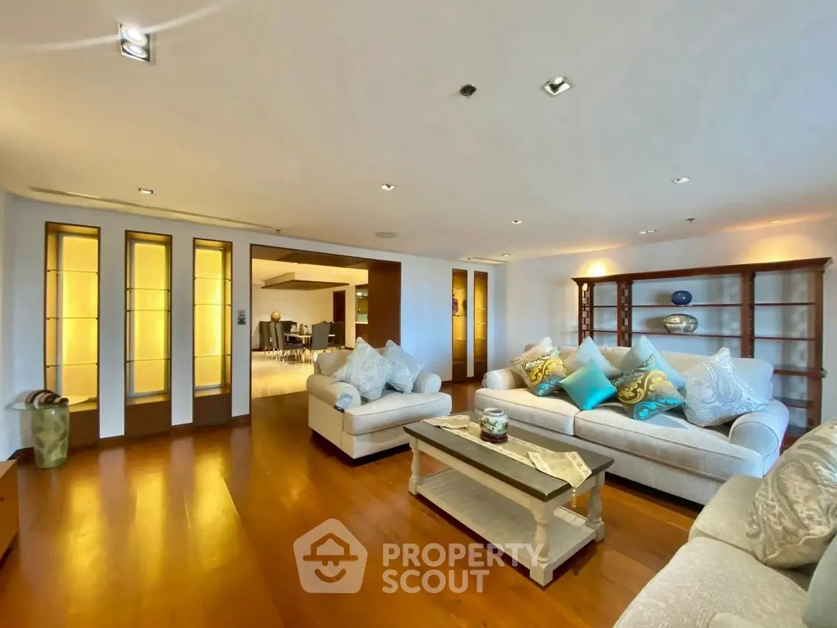 Spacious living room with elegant sofas and wooden flooring in a luxurious apartment.