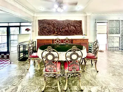 Elegant dining room with ornate chairs and intricate wall art in a spacious home