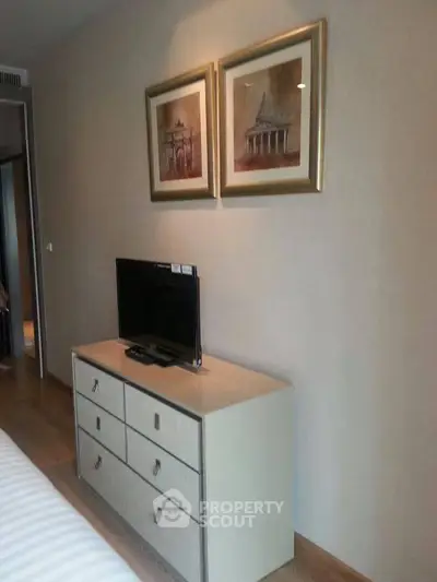 Stylish bedroom with modern dresser and wall art, perfect for contemporary living.