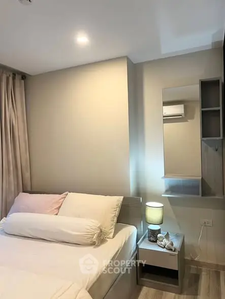 Cozy bedroom with modern decor and soft lighting, featuring a comfortable bed and stylish bedside table.