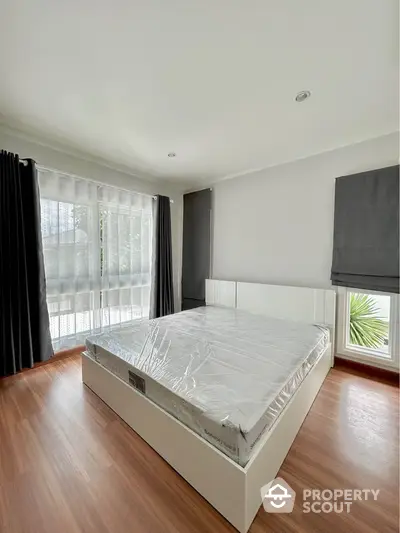 Spacious bedroom with large windows and modern design in a bright, airy home