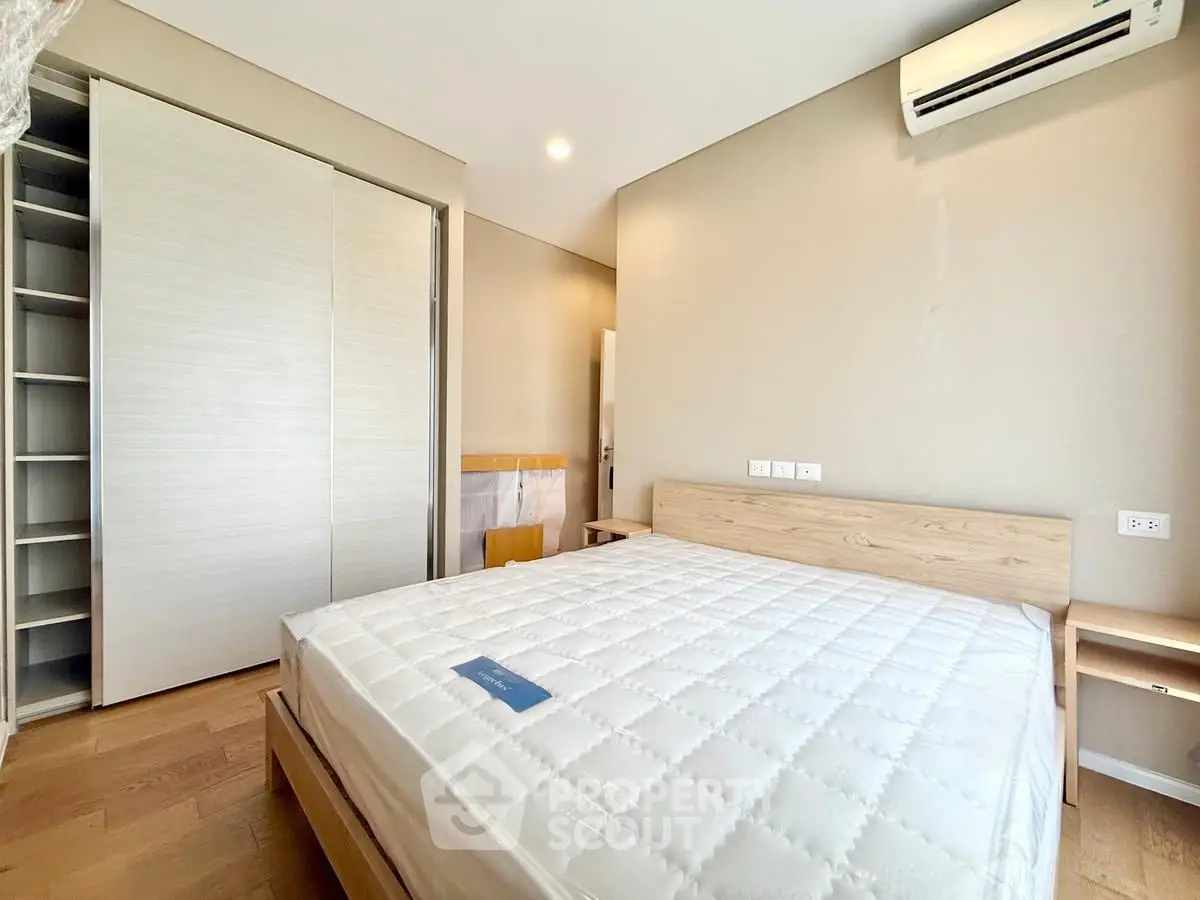 Spacious bedroom with modern design and built-in closet, featuring a comfortable bed and air conditioning.