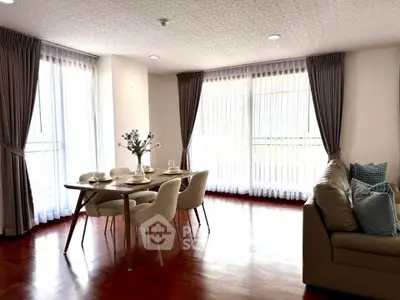 Spacious living room with elegant dining area and large windows for natural light.