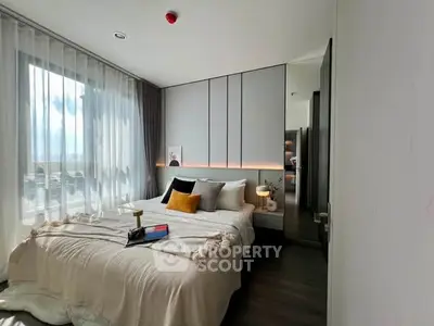 Modern bedroom with stylish decor and ample natural light, featuring a cozy bed and elegant furnishings.