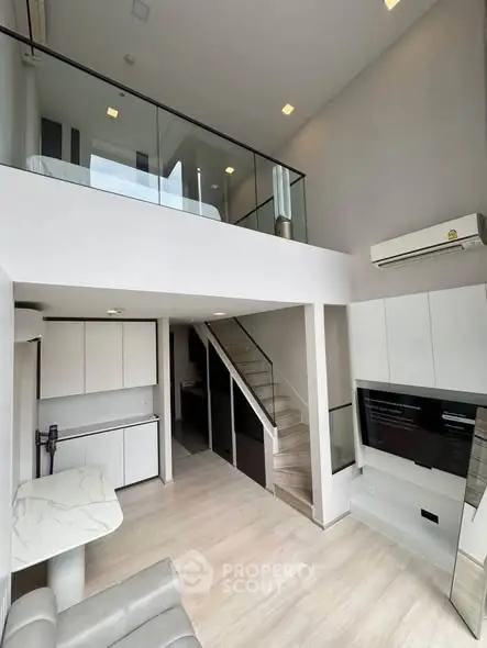 Modern loft apartment with mezzanine bedroom and sleek open kitchen design.
