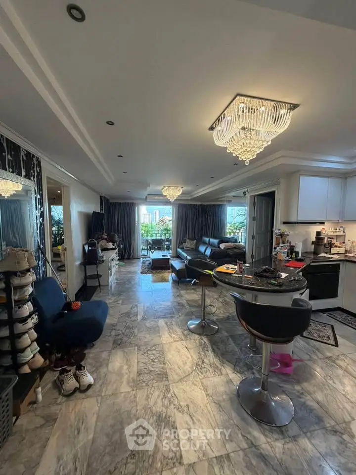 Spacious open-plan living room with modern kitchen and elegant lighting in luxury apartment.
