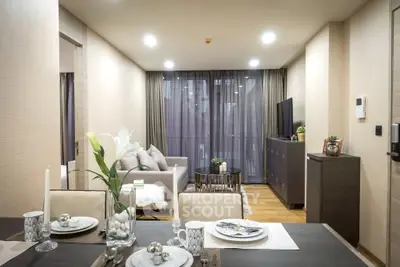 Modern living room with elegant decor and open dining area, featuring stylish furniture and ambient lighting.