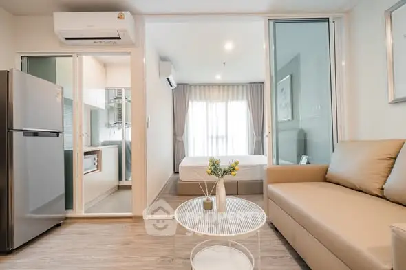 Modern studio apartment with open layout, featuring cozy living area and sleek kitchen appliances.