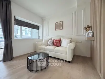 Stylish living room with modern decor and natural light, featuring a cozy white sofa and chic coffee table.