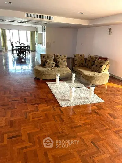 Spacious living room with elegant parquet flooring and stylish furniture, perfect for modern living.