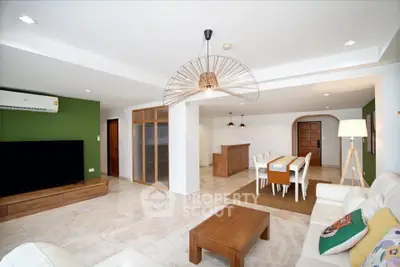 Spacious modern living room with open dining area, featuring stylish furniture and elegant lighting.