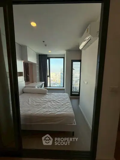 Modern bedroom with city view and air conditioning in high-rise apartment