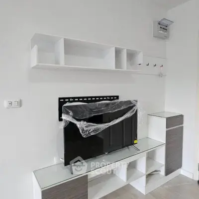 Modern living room with sleek TV stand and wall-mounted shelves in a minimalist design.