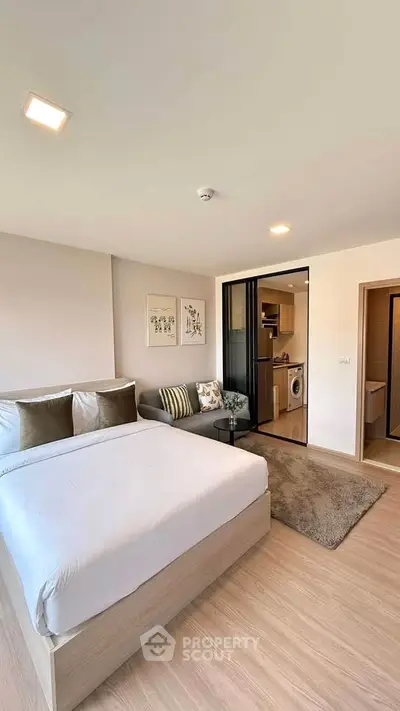 Modern studio apartment with cozy bedroom and open kitchen layout, featuring stylish decor and natural light.