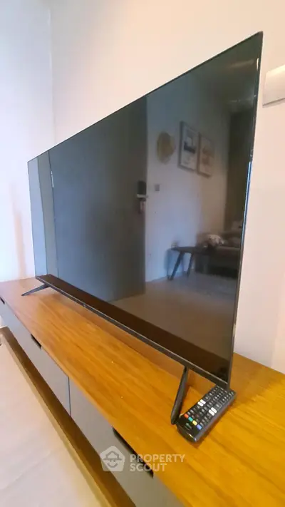 Modern living room with sleek flat-screen TV on stylish wooden console.