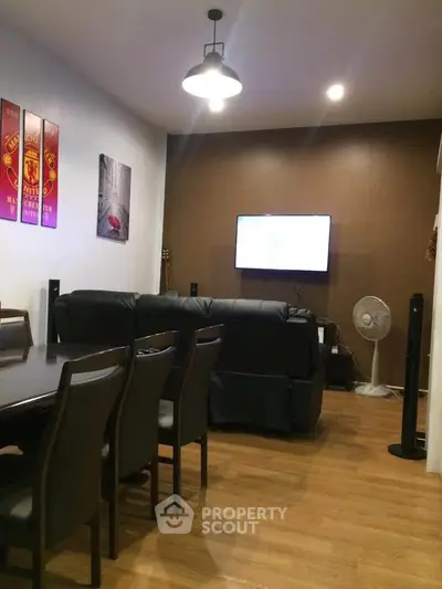 Cozy living room with modern decor and wall-mounted TV, perfect for family gatherings.