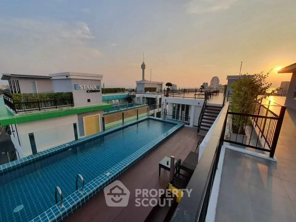 Stunning rooftop pool with panoramic city views at sunset in modern condo complex.
