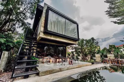 Modern architectural home with large glass windows and lush garden view.