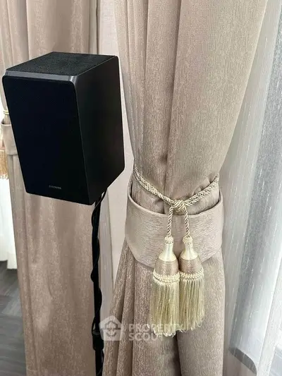 Elegant interior with luxurious curtains and modern speaker setup.