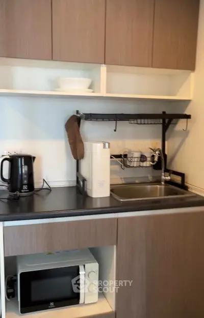 Modern kitchen with sleek cabinetry, microwave, and appliances for efficient cooking.