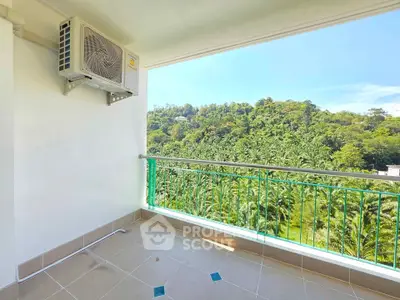 Spacious balcony with lush green view and air conditioning unit