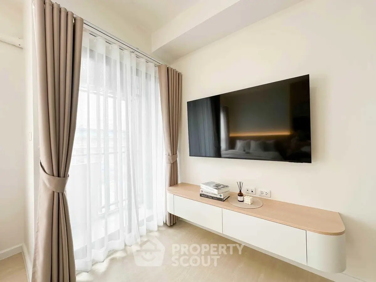 Modern living room with wall-mounted TV and elegant curtains
