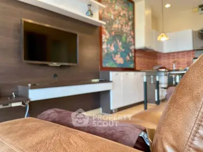 Modern living room with wall-mounted TV and stylish kitchen in open layout