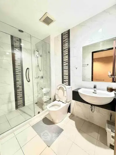 Modern bathroom with glass shower and sleek fixtures in a contemporary apartment.