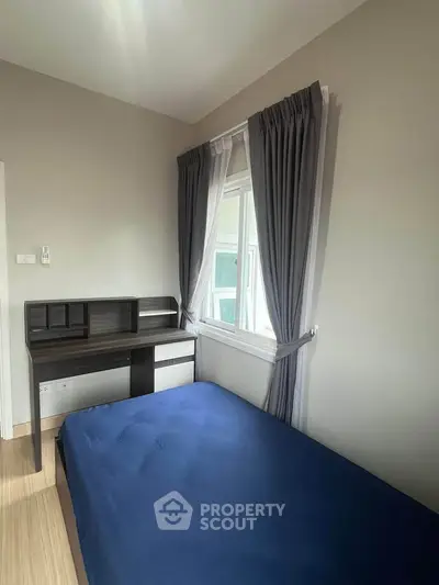 Cozy bedroom with a single bed and study desk, featuring a large window with elegant curtains.