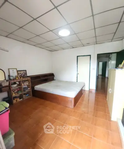 Spacious bedroom with wooden flooring and ample storage in a cozy apartment.