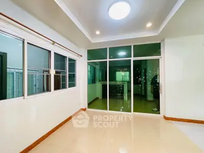 Spacious room with large windows and sliding glass doors, perfect for natural light.