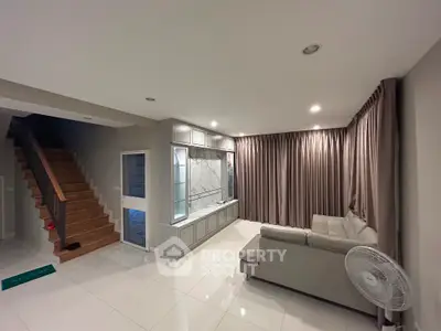 Spacious modern living room with elegant staircase and cozy seating area