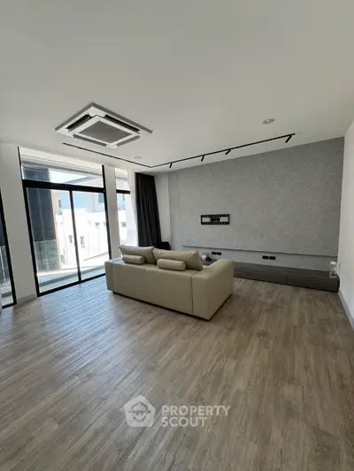 Spacious modern living room with large windows and sleek flooring