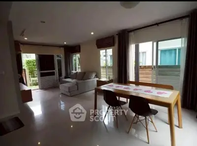 Spacious modern living room with dining area and large windows for natural light.