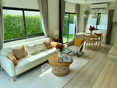 Modern living room with elegant decor and garden view, featuring cozy seating and stylish dining area.