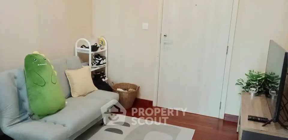 Cozy living room with plush sofa, TV, and stylish decor in modern apartment.