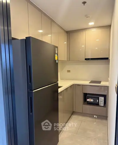 Modern kitchen with sleek cabinets and appliances, featuring a compact design and contemporary finishes.