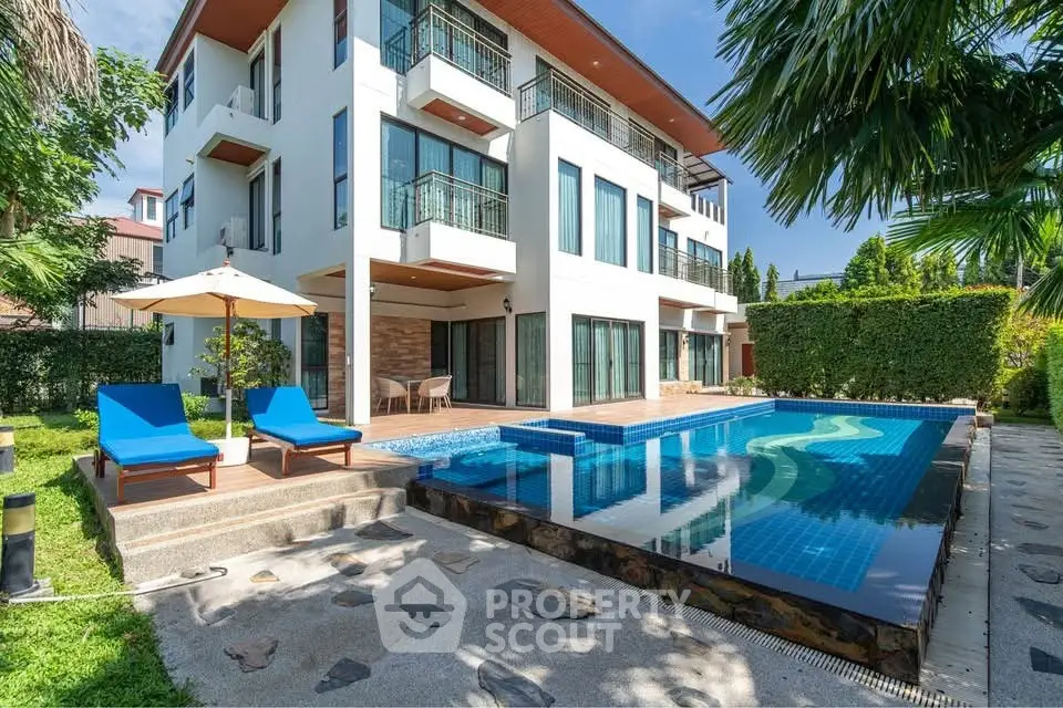 Luxurious modern villa with private pool and sun loungers, perfect for relaxation and entertaining.