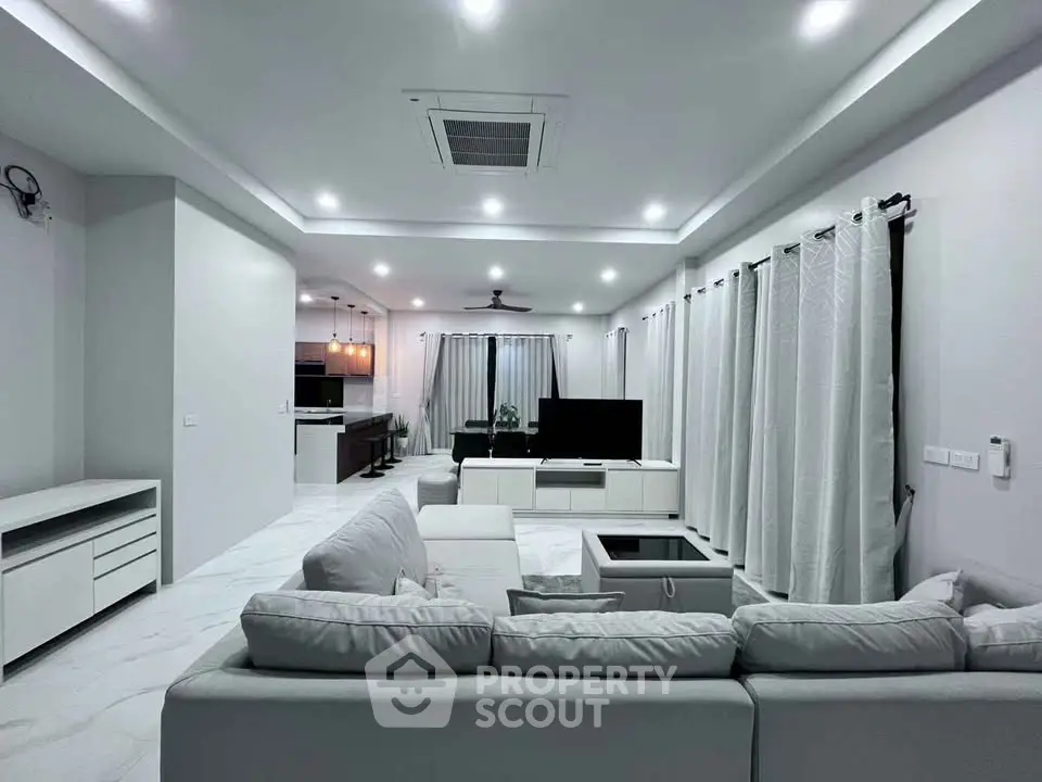 Spacious modern living room with elegant white decor and open layout, perfect for family gatherings.
