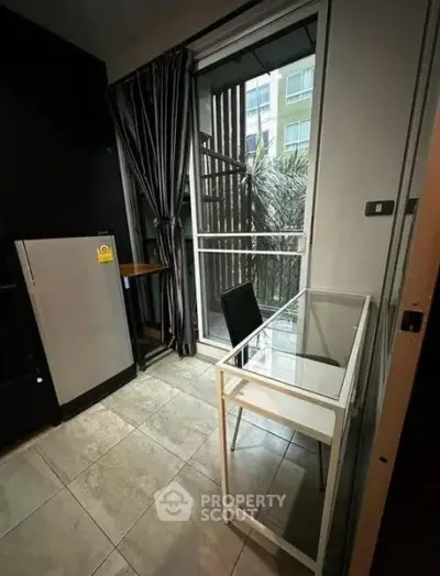 Cozy study area with glass desk and balcony view in modern apartment