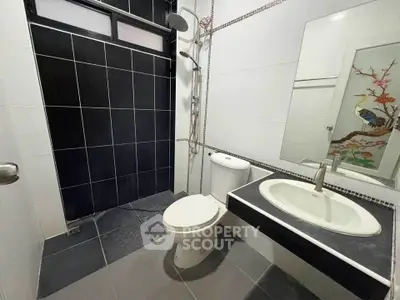 Modern bathroom with sleek black tiles and stylish fixtures