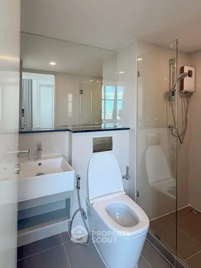 Modern bathroom with glass shower and sleek fixtures in a contemporary apartment.