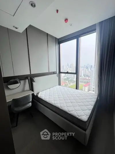 Modern bedroom with city view, featuring a comfortable bed and stylish decor in a high-rise apartment.