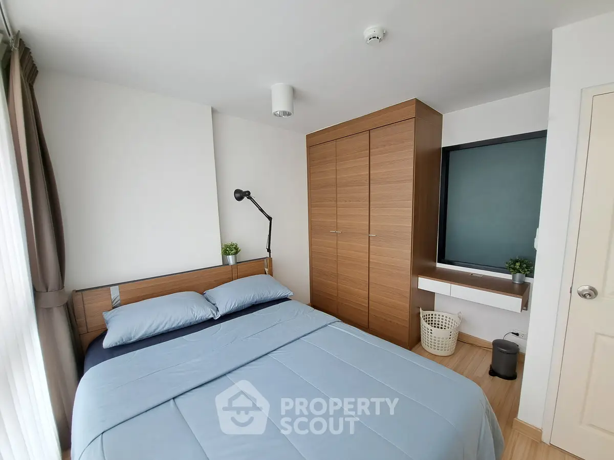 Modern bedroom with wooden wardrobe and cozy blue bedding