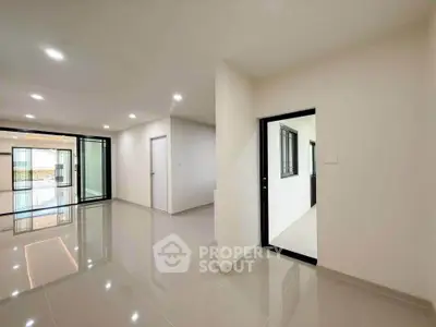 Spacious modern living room with sleek tile flooring and ample natural light.