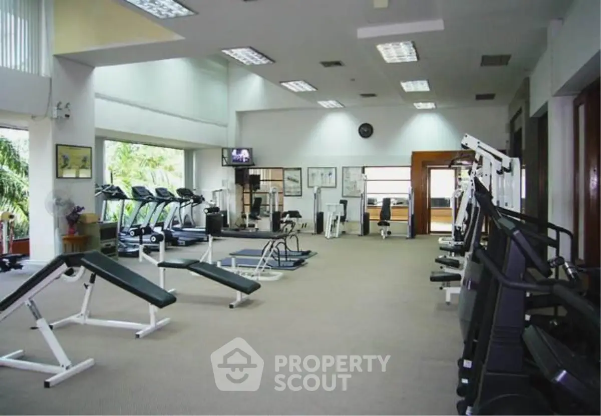 Spacious gym with modern equipment and natural light, ideal for fitness enthusiasts.