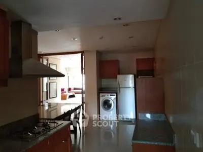 Spacious kitchen with modern appliances and open layout leading to living area.